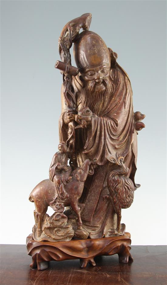 A large Chinese soapstone group of Shou Lao, Qing dynasty, 44.5cm, restorations, wood stand